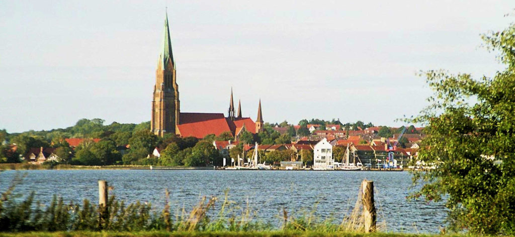 Der Dom der Stadt Schleswig mit der Schlei im Vordergrund.